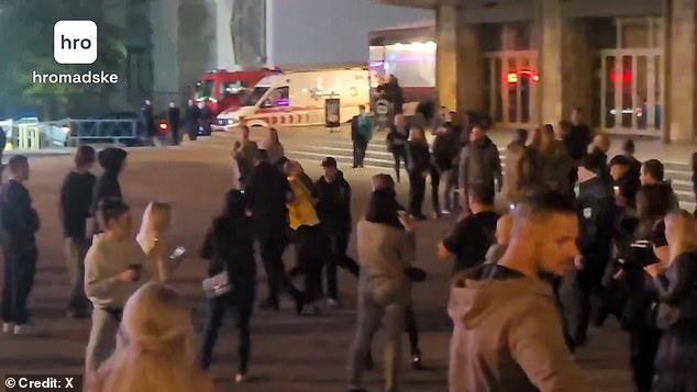 A man dressed in yellow is seen being dragged away by police officers (pictured)