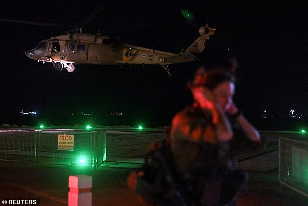 An Israeli soldier watches as a military helicopter takes off after dropping off patients who were injured in a drone strike.