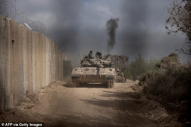 An Israeli battle tank seen entering Lebanon from northern Israel at the southern Lebanese border point of Naqoura (pictured) on Sunday.