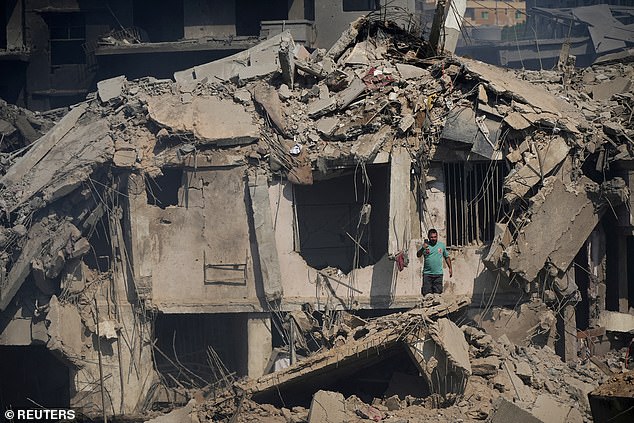 A civil defense member stands amid the damage caused after what security sources said was an Israeli attack on a market in southern Lebanon.