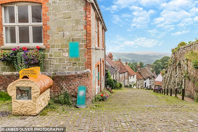 Button Cottage can be seen in the photograph located between two white properties.