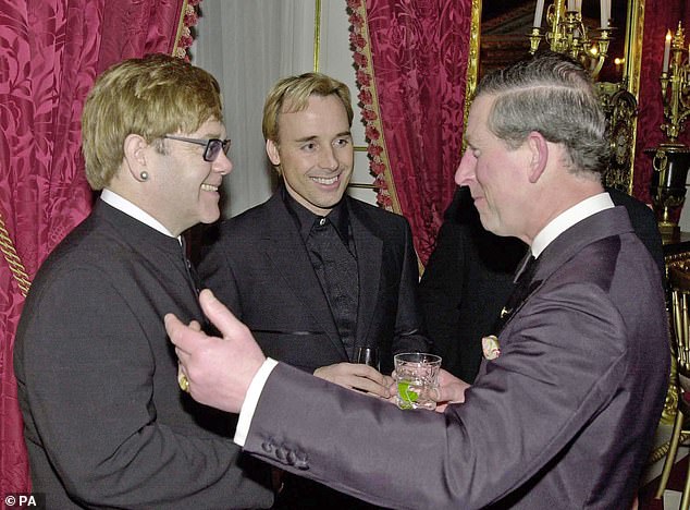 A younger Elton John is shown chatting with the then Prince of Wales at St James's Palace in 2001.