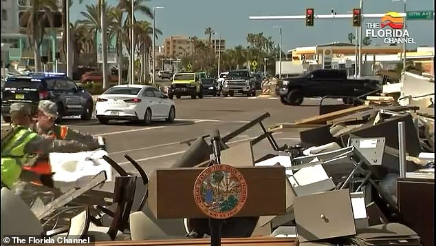 Florida National Guard troops help clear debris and stack it for removal on Treasure Island, Florida, over the weekend ahead of DeSantis' news conference.