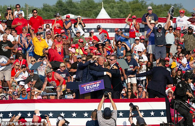 Republican candidate Donald Trump is seen with blood on his face surrounded by Secret Service agents as he is led off stage at a campaign event in Butler, Pennsylvania, on July 13, 2024.