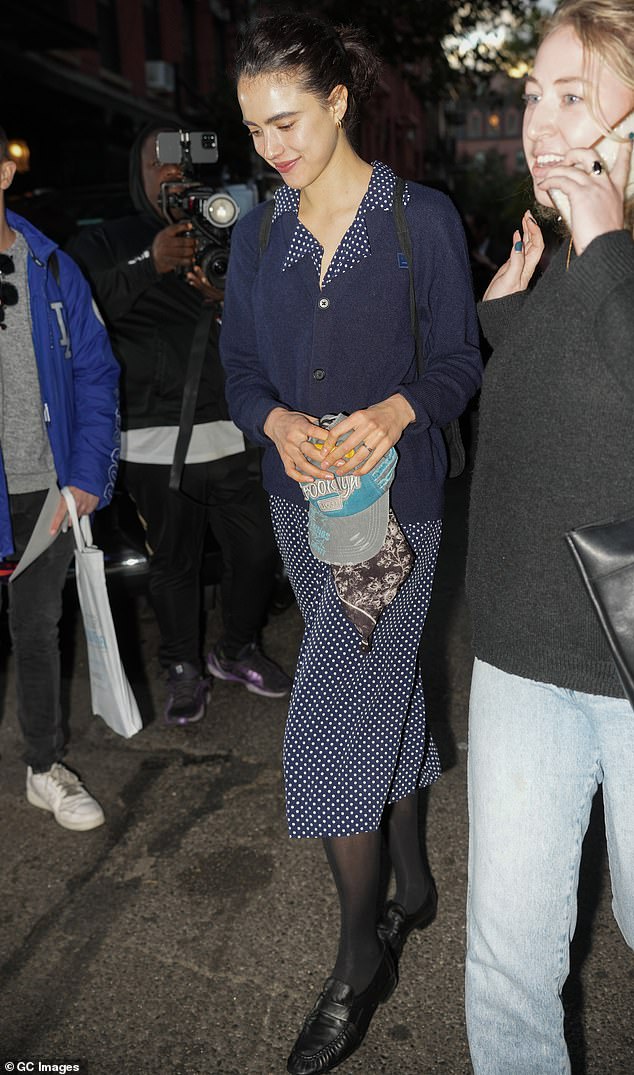 The Poor Things actress wore her dark hair up in a messy bun and covered up with black tights while completing her look with black loafers.