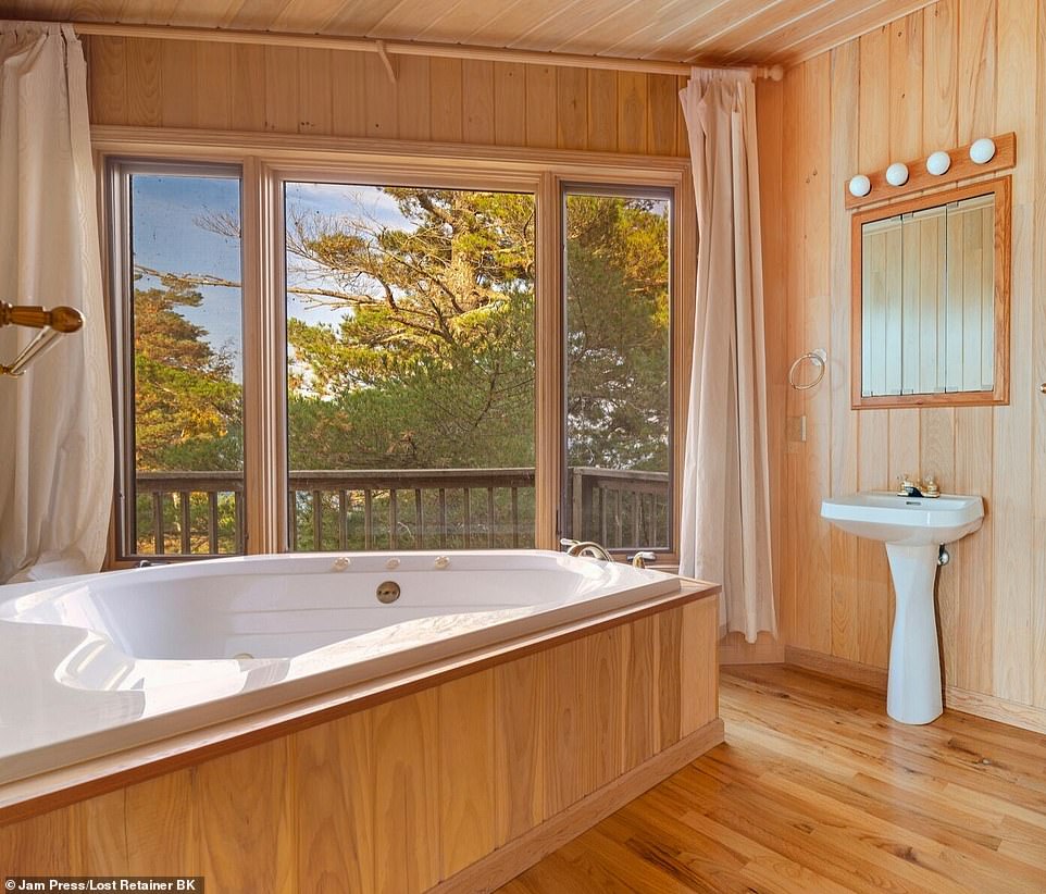 Upstairs features a master bedroom suite offering panoramic views of the surrounding waters and a hot tub.