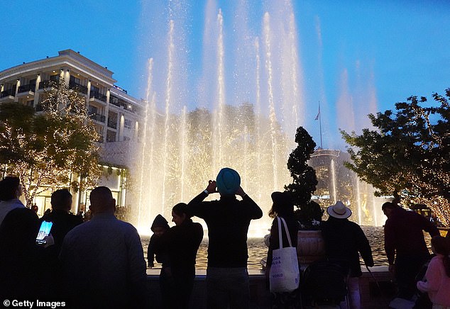 Visitors gather to appreciate the water show at the fountain.