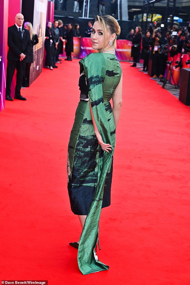 The elegant dress included an over-the-shoulder train and the star added a pair of metallic green pumps to her look.