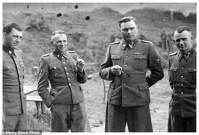 SS officers are photographed in front of a building at an SS retreat outside Auschwitz in 1944. From left to right; Josef Mengele, Josef Kramer, Rudolph Hess and Karl Hoecker