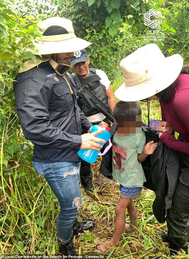 Rescue workers provide water and a jacket to Joel Acosta after he was located near a cabin on Friday, six days after he escaped.