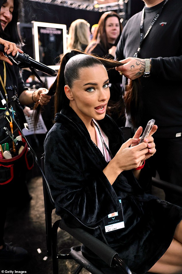 Adriana Lima, who returned to the Victoria's Secret runway after a six-year retirement, caught up on text messages during her stint in the hair and makeup chair.