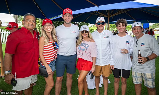 Carlos Gavidia (far left), the organizer of the boat parade, is seen posing for a photo with other MAGA supporters, including Trump's son Eric (center).