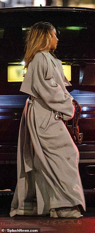 The American singer, 35, put on a busty display in a gray crop top, paired with stylish cargo pants and a trench coat.