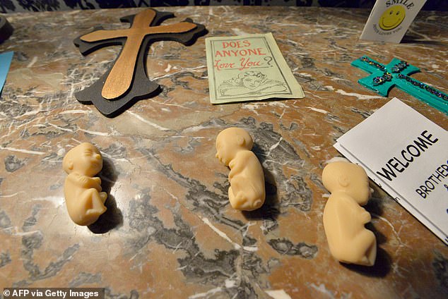 Items, including tiny model fetuses, intended to represent an evangelical Sunday school and a conversion school decorate the tables of the Satanic Temple in Salem, Massachusetts.