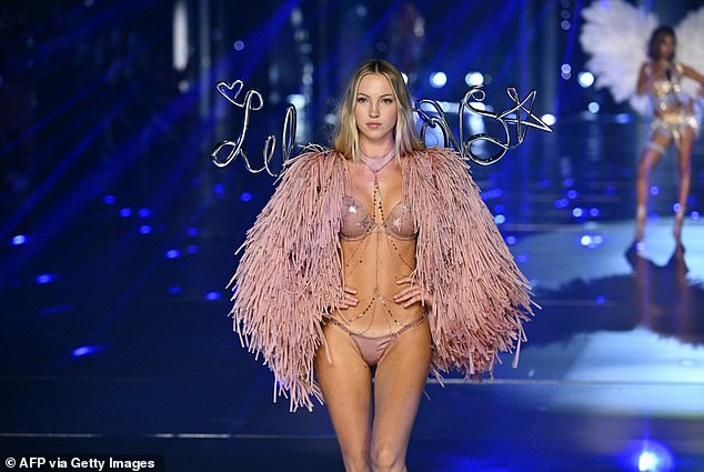 She draped a pink tassel shawl over her shoulders and dazzled the look with bright pink body jewelry and silver strappy heels.