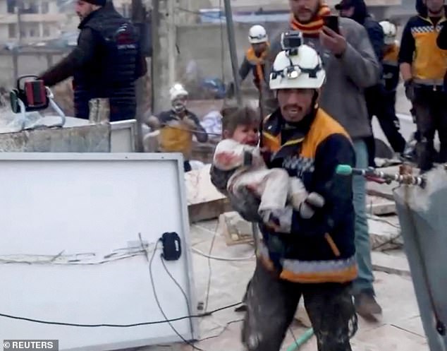 Pictured: A rescuer pulls an injured child from the rubble of a collapsed building in rebel-held Syria, following a deadly earthquake that hit Turkey and Syria in 2023.