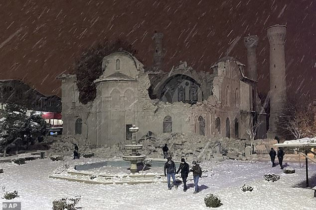 People walked past a mosque destroyed by an earthquake in Malatya in 2023