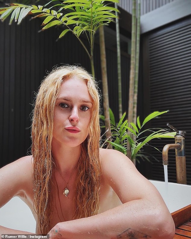 Posing in the bathtub, she covered her modesty with a strategically placed wooden shelf and crossed her arms over her chest.