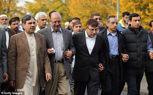 Dr. Abdul Shakoor (center) and members of the Muslim community follow the funeral procession to the crematorium after a prayer service in October 2012.