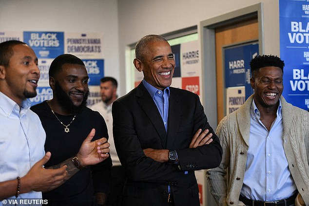 Former President Barack Obama laughs as he listens to a presentation at a campaign office in Pennsylvania.