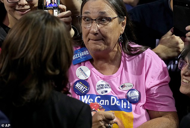 Democratic vice presidential candidate Kamala Harris (left) waves to a supporter after speaking at a campaign rally at Erie Insurance Arena in Erie, Pennsylvania.