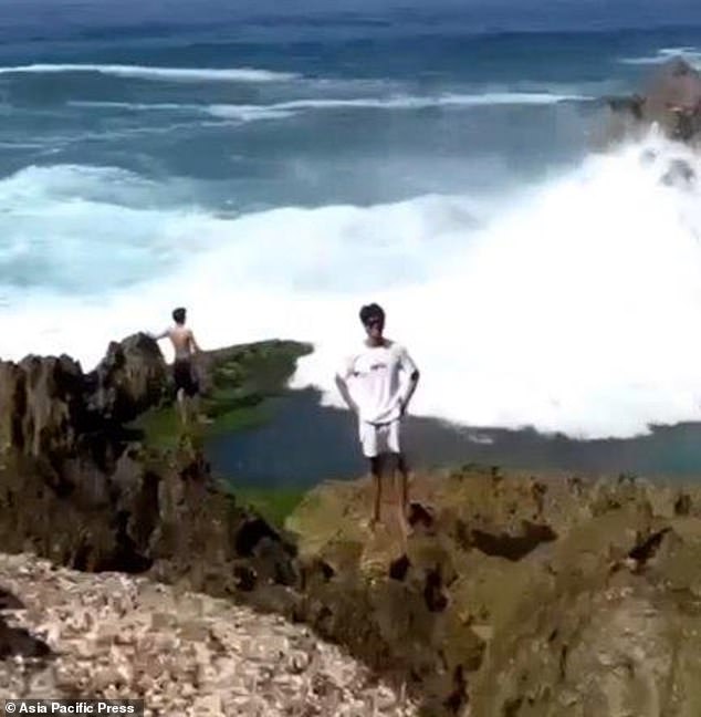 Simanjuntak could be seen standing behind his friend on the rock before he was swept away by the waters.