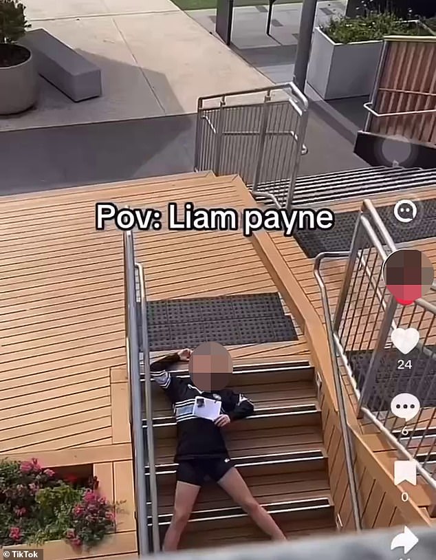 In the video, a girl is seen running and pretending to jump from the edge of a balcony. Moments later, another student is seen lying on the ground on the lower level of the building.