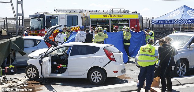 Police set up a blue tent over one of the vehicles involved in the accident (pictured).