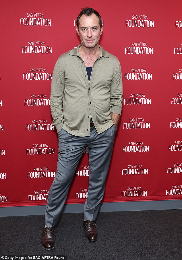 The actor looked dapper for the event wearing a beige cardigan, gray pants and brown shoes.