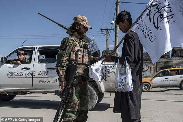 The Islamic Republic has said it hopes to achieve two million deportations by March next year. Pictured: A Taliban security personnel talks to a flag seller in front of the Eid Gah mosque in Kabul on April 20, 2023.