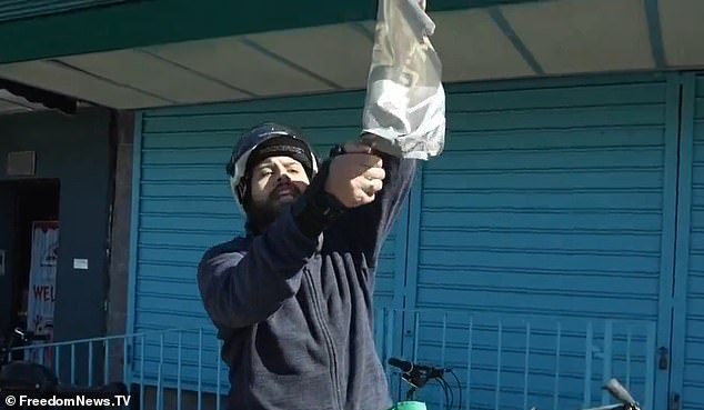 He then stops on a sidewalk and tries to set fire to a flag but his lighter fails.