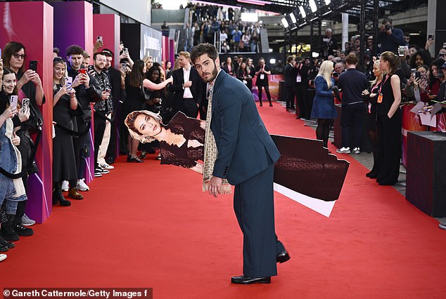 When Andrew entered the venue, he tucked the life-size version of Florence under his arm and ran into the theater, striking a fake furtive pose and performing for the crowd.