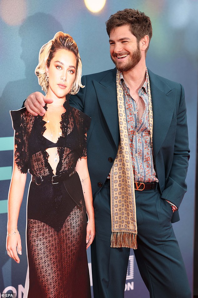 He then stood next to her and put his arm over the cutout's shoulders as he smiled at his co-star's position in