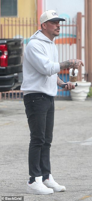 Jax kept it casual in a light gray hoodie and black jeans.