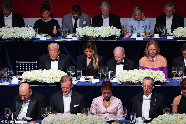 President Donald Trump and his wife Melania Trump bow their heads in prayer during the Alfred E. Smith Foundation's annual dinner at the Hilton Midtown in New York on October 17, 2024.