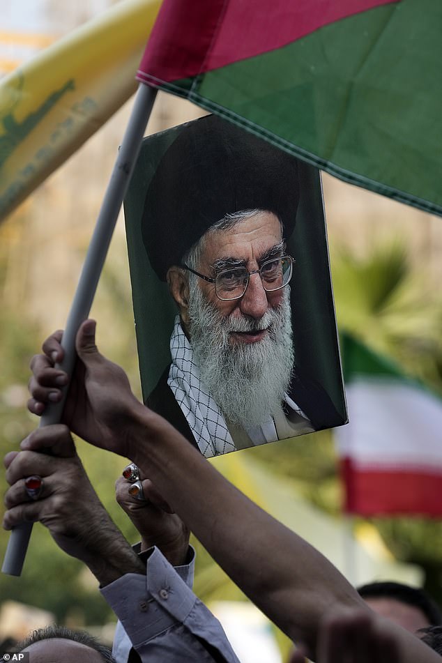 Iranian protesters wave a Palestinian flag and hold a sign of Supreme Leader Ayatollah Ali Khamenei at an anti-Israel rally.