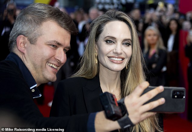 Letting her blonde locks fall over her shoulders, Angelina accessorized her outfit with a pair of gold earrings.