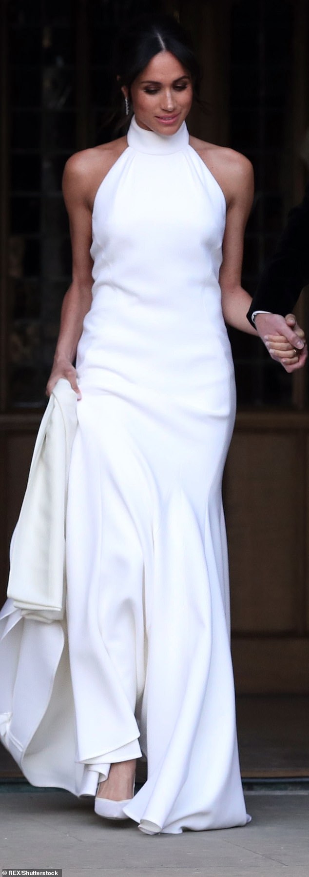 The Duchess wore this Stella McCartney halterneck dress to her wedding reception—it showed off Meghan's Pilates-polished shoulders.