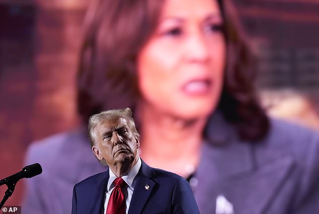 Trump watches a video showing Democratic presidential candidate Kamala Harris during a campaign event Friday in Detroit.