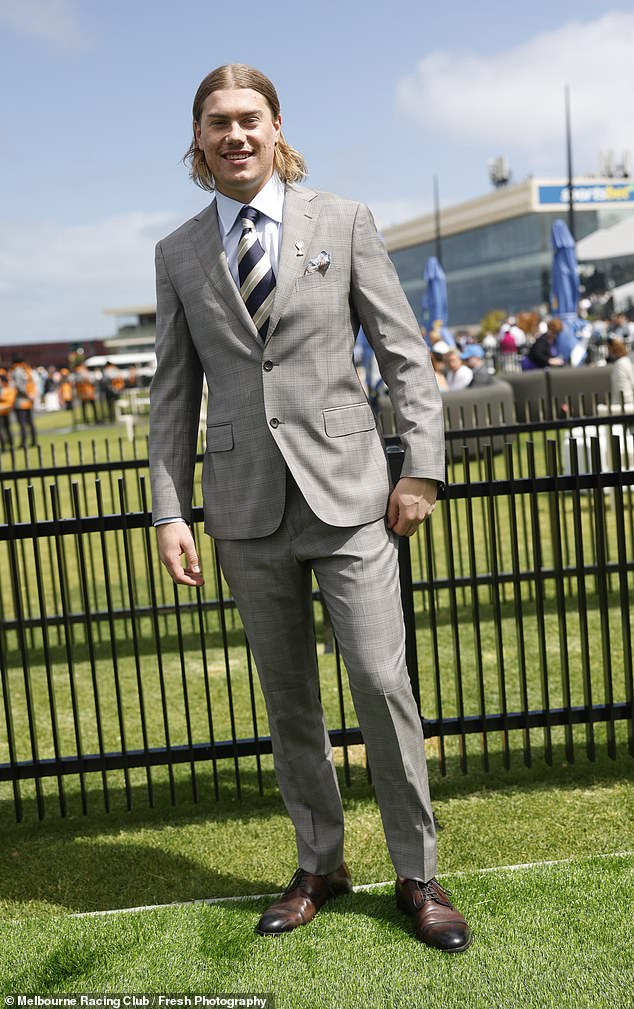 AFL star Harley Reid looked dapper in a smart gray suit, which he teamed with a white shirt, striped tie and brown shoes.