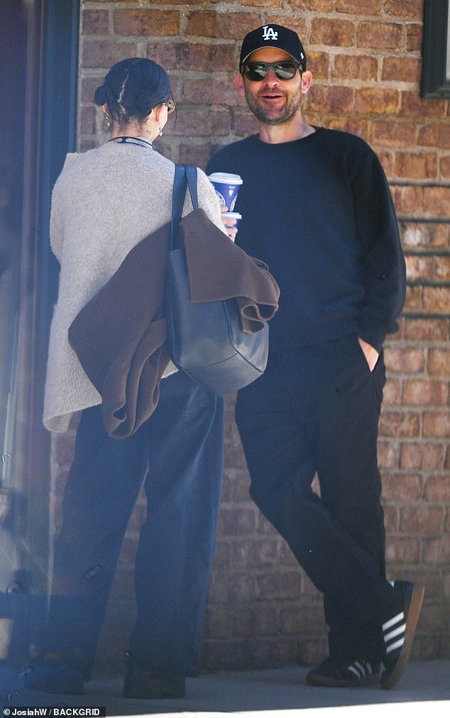 Kravitz wore baggy indigo blue jeans with a light gray cardigan and black boots, while Tobey wore black pants and black and white Adidas sneakers.