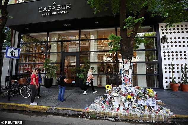 People stand next to tributes left outside the Casa Sur Hotel in Buenos Aires, where Liam was found dead on Thursday.