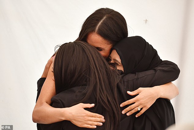 Meghan shares a hug with women she worked with at Hubb Community Kitchen in 2018