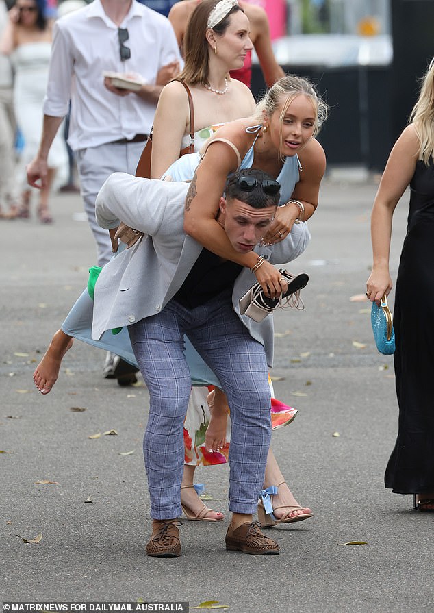 A young woman hitchhikes as she leaves Royal Randwick after the Everest race.