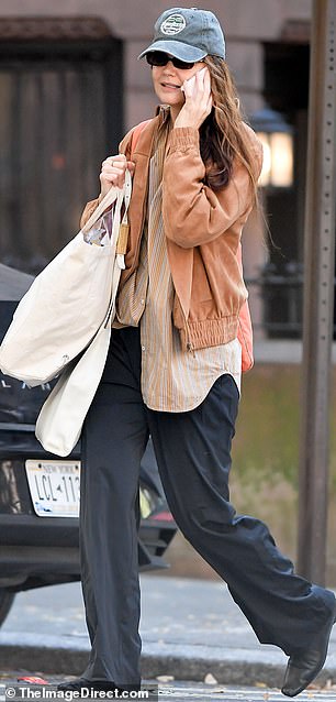 Stepping out in Manhattan on Saturday, Katie rocked an asymmetrical look, tucking her striped blouse in on one side and leaving the other out.