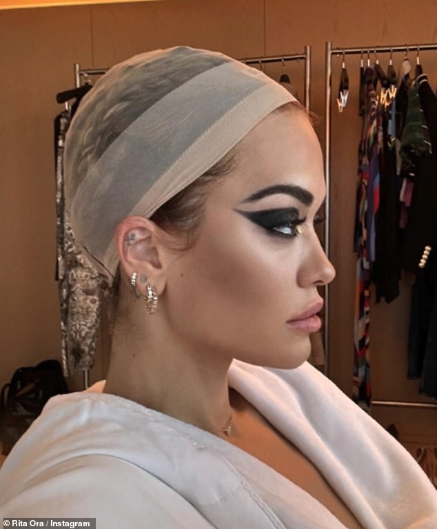 In BTS photos, Rita sits in the makeup chair before the show