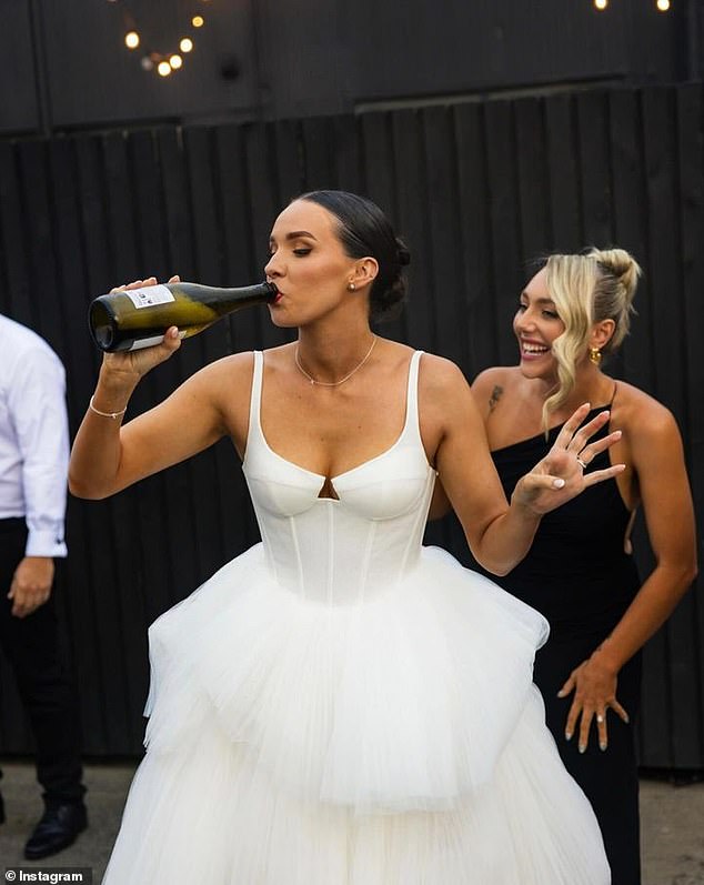 While drinking champagne straight from the bottle, the happy bride changed into a much more comfortable outfit by removing the bottom layers of her wedding dress.