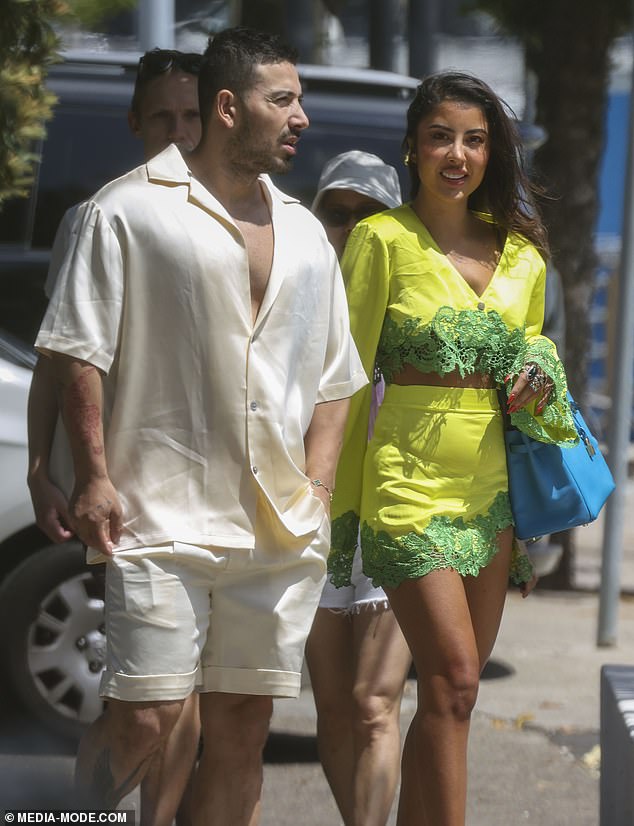 Jono, 33, offered a hint of masculine cleavage in an oversized apricot shirt that featured a wide, open neckline. She completed her look with shorts of the same delicate tone and white sneakers.