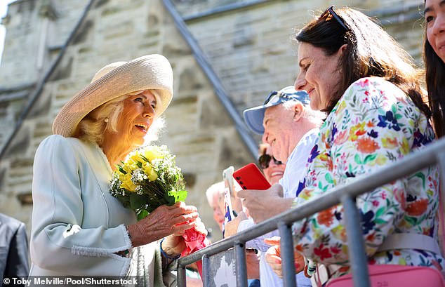 Queen Camilla thanks a supporter for offering her flowers outside St Thomas' Anglican Church