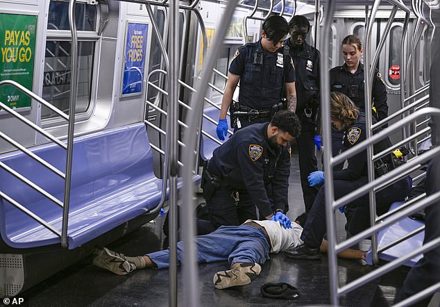 New York police officers attempt to revive Jordan Neely as he lies on the floor of an F train on May 1.